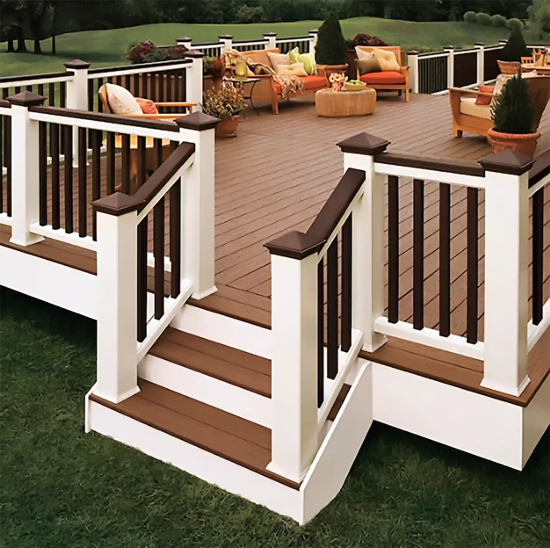 Composite deck with a wood-like finish featuring white railings and dark posts, along with a cozy seating area.